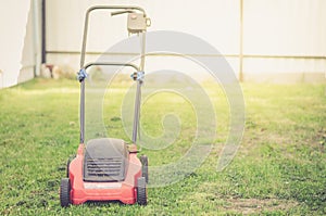 Lawn mower cutting green grass/mowing lawn on the grass in the c