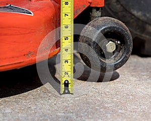 Lawn mower deck height adjustment and tape measure