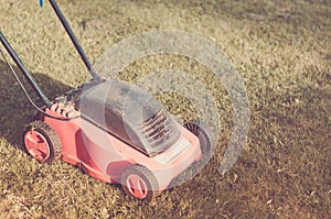 Lawn mower on the grass/lawn mower on the grass. Selective focus. Toned