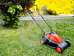 Lawn mower on green grass in a modern garden. Territory care. Selective focus