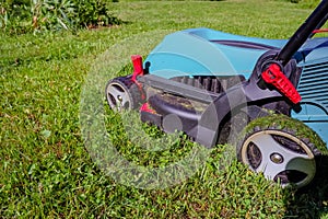 Lawn mower on green grass. mower cutting fresh grass in backyard, garden service.equipment, mowing, gardener, care, work