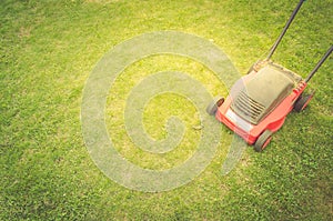 Lawn mower on a green lawn/lawn mower on a green lawn. Top view and copyspace