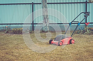 Lawn mower on a green lawn/mowing lawn on the grass in the cottage yard. Toned