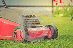 lawn mower on the lawn/red lawn mower on summer meadow. Selective focus