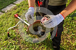 Lawn mower pulls the line out of the trimmer coil. Maintenance of garden tools