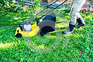 lawn mower on a sunny day, man mowing the lawn in the backyard