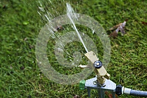 Lawn sprinkler with a blurred background.