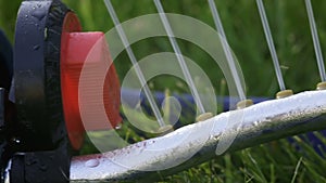 Lawn sprinkler spaying water over green grass.