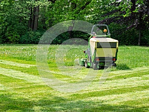 Lawn tractor on a meadow in park