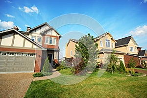 Lawn with trees and shrubs between two cottages