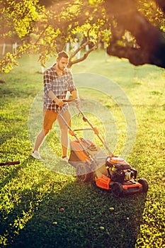 Lawncare concept - maintenance with gardener working and cutting grass photo