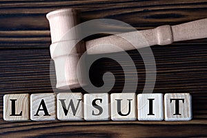 LAWSUIT - word on wooden cubes on background of judge\'s gavel