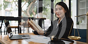 Lawyer business woman reading law book and agreement contract