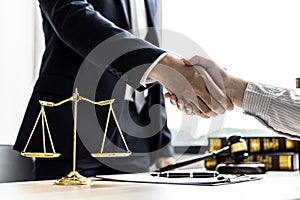 Lawyer and client shake hands, sign a lawsuit for the client.