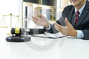 A lawyer is consulting a legal job in his office had gavel and balance