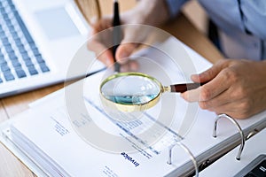 Lawyer Examining Invoice Using Magnifier Glass