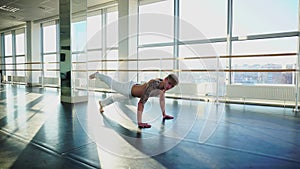 Lawyer with good body in sportswear doing different pushups in gym