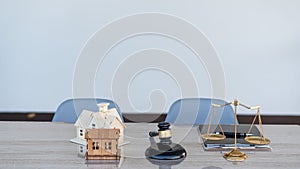 Lawyer hammer and scales with home design on desk and tablet