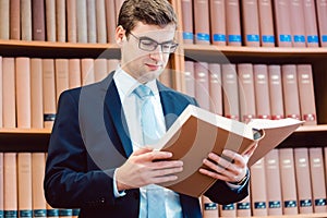 Lawyer in his office reading precedents in thick books