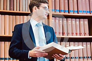 Lawyer in his office reading precedents in thick books