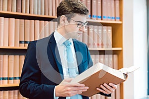 Lawyer in his office reading precedents in thick books