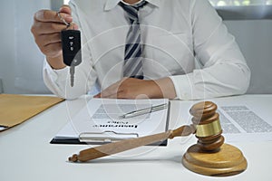 Lawyer holding car key, Judge gavel hammer on Lawyer desk