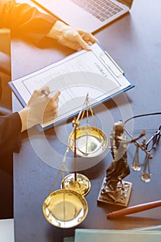 Lawyer holding contract documents in hand and preparing to sign a consulting contract for a team of business people who need legal