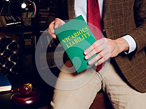 Lawyer holds a book about vicarious liability. photo