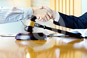 Lawyer or judge gavel with balance handshake with client