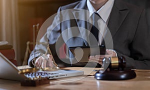 Lawyer office. gavel of Justice with scales and lawyer working on a laptop.