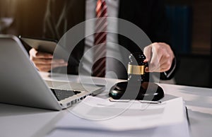 Lawyer office. gavel of Justice with scales and lawyer working on a laptop.