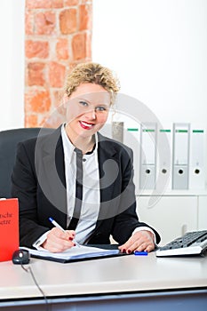 Lawyer in office with law book working on desk