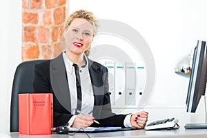 Lawyer in office with law book working on desk