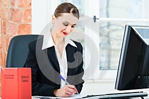 Lawyer in office making notes in a file