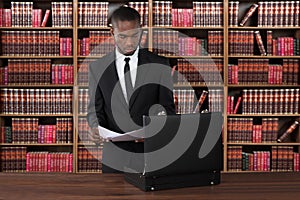 Lawyer With Papers And Briefcase At Desk