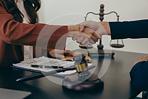 A lawyer shakes hands with a businessman to close a deal with a lawyer to discuss the contractual terms
