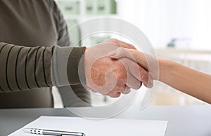 Lawyer shaking hands with client in office