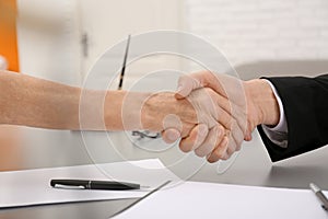 Lawyer shaking hands with client in office