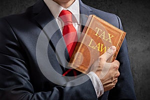 Lawyer stands with collection of tax regulations