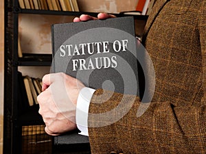 Lawyer takes a statute of frauds book from the shelf.