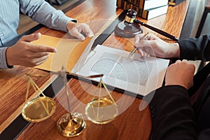 Lawyer working with client discussing contract papers with brass scale about legal legislation in courtroom, consulting to help