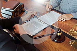 Lawyer working with client discussing contract papers with brass scale about legal legislation in courtroom, consulting to help
