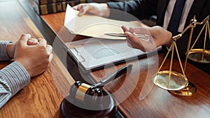 Lawyer working with client discussing contract papers with brass scale about legal legislation in courtroom, consulting to help