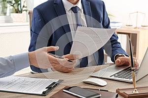 Lawyer working with client at table in office, focus