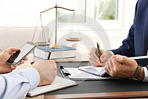 Lawyer working with client at table in office, focus