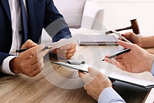 Lawyer working with clients at table in office, focus