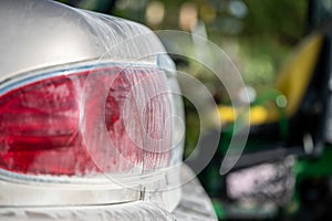 Layer of dust coving the taillight of a car after driving down a gravel road