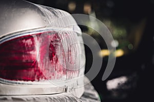 Layer of dust coving the taillight of a car after driving down a gravel road