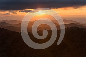 Layer of mountains in the mist at sunset time with burning sky,