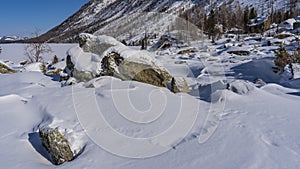 A layer of pure untouched snow lies on large boulders